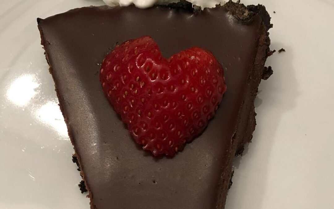 piece of chocolate ganache cake with heart shaped strawberry